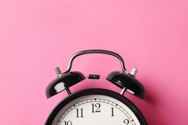 Pembe arka planda siyah alarm saati, üst görünüm