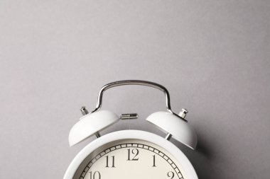 Gri arka planda beyaz alarmlı saat, üst manzara. Metin için boşluk