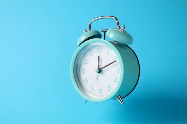 Açık mavi arkaplanda turkuaz alarm saati