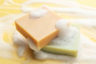 Sarı arka planda köpüklü sabun çubukları