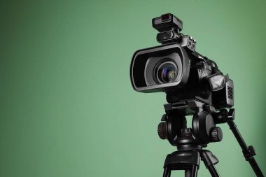 Grimsi yeşil arkaplan üzerine modern profesyonel video kamera, metin için boşluk