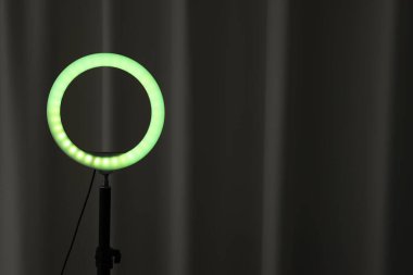 Siyah perdenin yanında parlayan bir lamba. Metin için boşluk