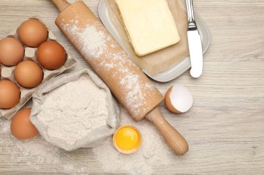 Yuvarlanan iğne ve farklı malzemeler açık ahşap masada, düz yerde.