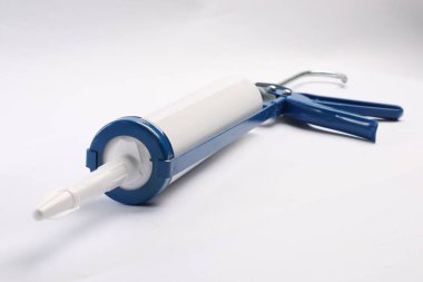 Beyaz arka planda bir tutkal tabancası. Yapı aracı