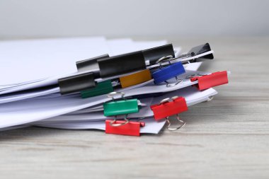 Tahta masadaki kağıtların olduğu ataçlar, yakın plan.