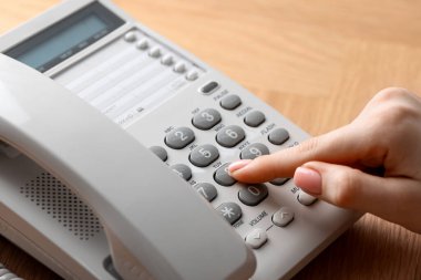 Ahşap masada telefonla arayan kadın, yakın plan.