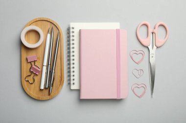 Gri arkaplanda farklı kırtasiye malzemesi, düz konum