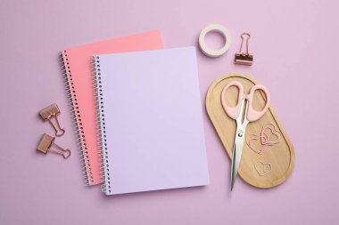 Kağıt ataçları ve leylak arkaplan üzerindeki diğer farklı kırtasiyeler, düz konum