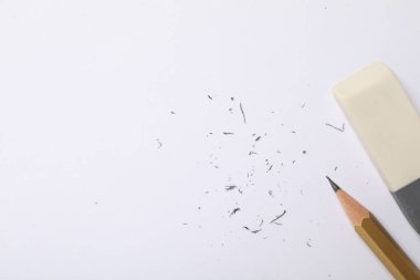 Silgi, kalem ve kırıntılar beyaz arka planda, düz yerde. Metin için boşluk