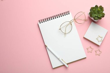 Ataç, diğer kırtasiye malzemeleri, pembe arka planda gözlük ve dekor, düz yatak. Metin için boşluk
