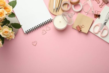 Ataçlar, diğer kırtasiye malzemeleri ve pembe arka planda dekor, düz yatak. Metin için boşluk
