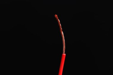 Siyah arkaplanda kırmızı şeritli elektrik kablosu, yakın plan.