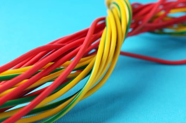 Açık mavi arkaplanda birçok renk elektrik kablosu, yakın plan
