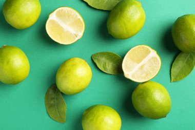 Yeşil arka planda bir sürü taze limon ve yaprak