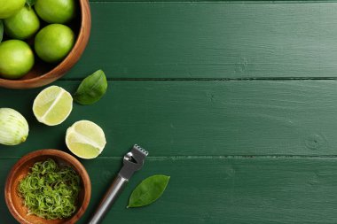 Limon tadı, taze meyveler ve yeşil ahşap masa üzerinde zester aletler, düz yatak. Metin için boşluk