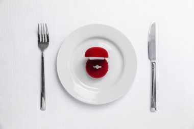 Güzel nişan yüzüğü ve beyaz arka planda romantik bir akşam yemeği için ayarlama.