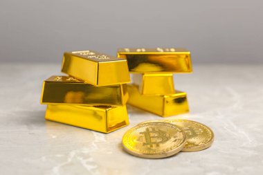 Gri mermer masada altın külçeler ve sikkeler, yakın plan.