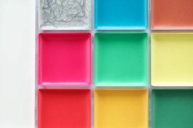 Beyaz arka planda parlak yüz boyası paleti, üst görünüm