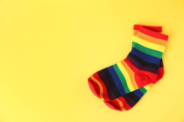 Sarı arka planda LGBT renginde bir çift çorap, üst manzara. Metin için boşluk