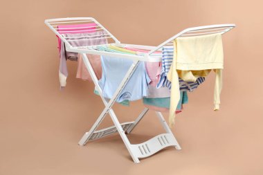 Bej arka planda temiz çamaşırlı kuru askı.