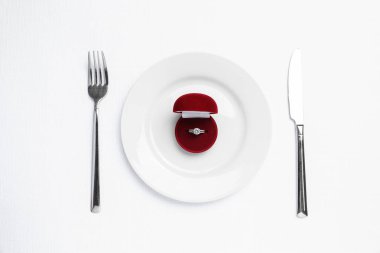 Güzel nişan yüzüğü ve beyaz arka planda romantik bir akşam yemeği için ayarlama.