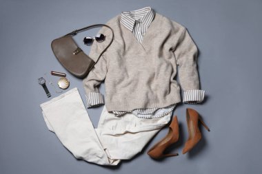 Zarif kadın kıyafeti. Gri arka planda şık kıyafetler ve aksesuarlar, düz yatış