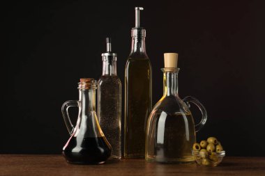 Salata sargıları ve zeytinler ahşap masada koyu arkaplanda.