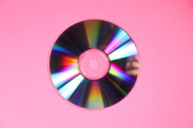 Pembe arka planda parlak bir CD, üst görünüm