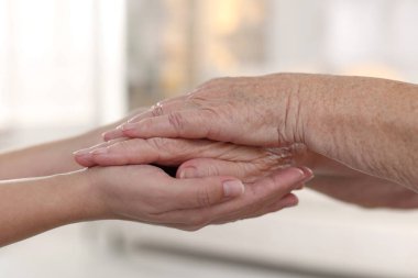 Son sınıf öğrencisine arka planda destek veren bakıcı, yakın plan. Yaşlı bakımı