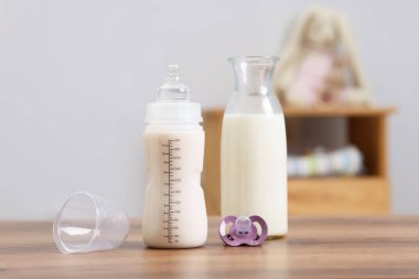 İçerideki ahşap masada süt, sürahi ve emzik.