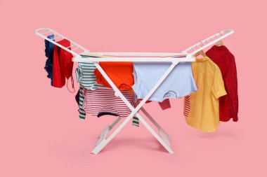 Açık pembe arka planda temiz çamaşırlı kuru askı.
