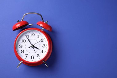 Mavi arka planda bir kırmızı alarm saati, üst manzara. Metin için boşluk