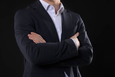 Siyah arka planda klasik takım elbiseli adam, yakın plan.