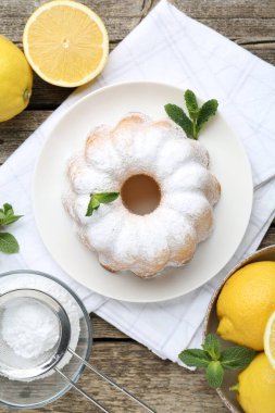 Lezzetli limonlu pasta pudra şekerli, taze meyveli ve nane şekerli ahşap masa, düz uzanmış.