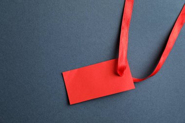 Gri arkaplanda kurdeleli boş etiket, üst görünüm