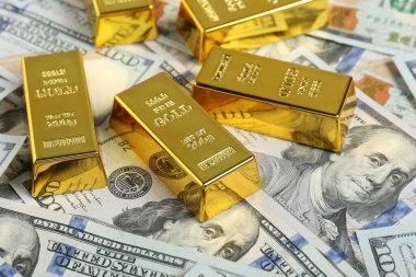 Parlak altın külçeler dolar banknotları, yakın plan