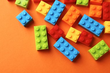 İnşaat oyuncağı. Turuncu zemin üzerinde renkli tuğlalar, düz zemin