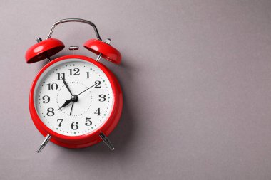 Açık gri arka planda bir kırmızı alarm saati, üst manzara. Metin için boşluk