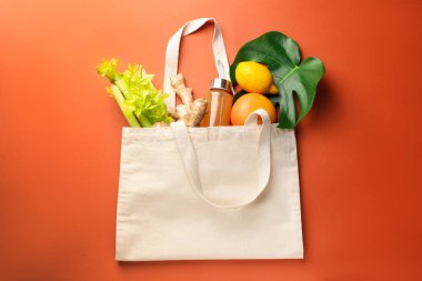 Turuncu arka planda ürünleri olan alışveriş torbası, üst manzara. Çevre dostu yaşam tarzı