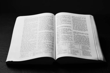 İngilizce İncil 'i siyah masada aç, yakın plan.