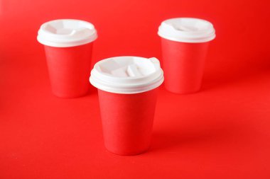 Kırmızı arka planda kağıt bardaklar, yakın plan. Tasarım için model