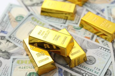 Parlak altın külçeler dolar banknotları, yakın plan