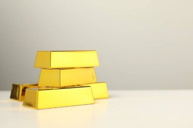 Gri arka planda parlak altın külçeler, yakın plan. Metin için boşluk