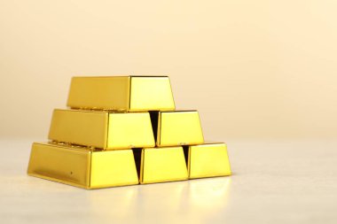 Bej arka planda altın külçeleri var, yakın plan. Metin için boşluk