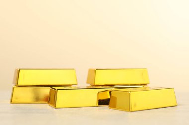 Bej arka planda parlak altın çubuklar, yakın plan