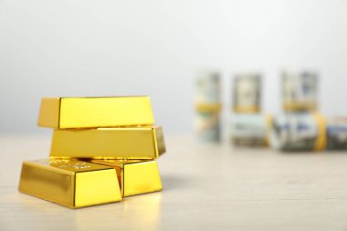 Gri arkaplanla yan yana duran altın külçeler. Yakın plan. Metin için boşluk