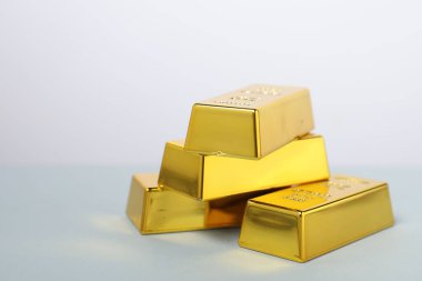 Masadaki altın külçeleri beyaz arka plana karşı, yakın plan. Metin için boşluk