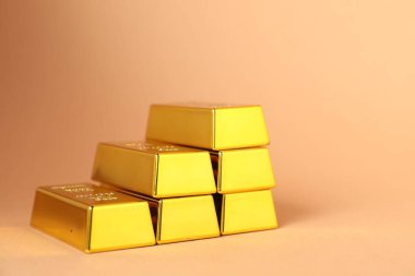 Açık mercan zemin üzerinde parlak altın külçeler, yakın plan. Metin için boşluk