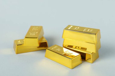 Açık gri arkaplanda parlak altın çubuklar, yakın plan