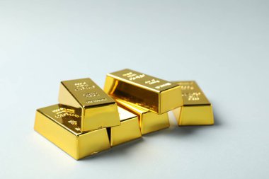 Açık gri arkaplanda parlak altın çubuklar, yakın plan